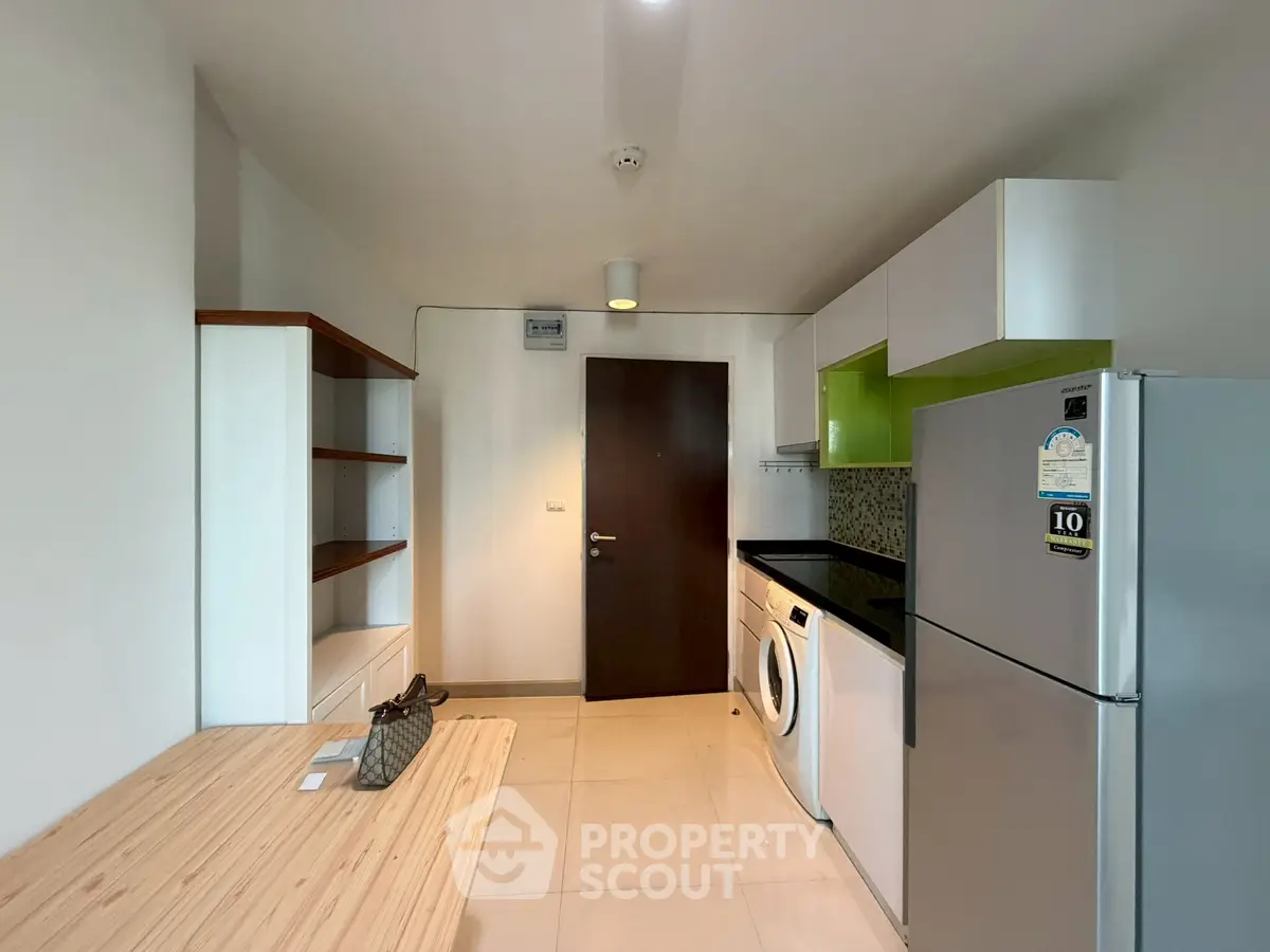 Modern kitchen with sleek appliances and ample storage in a contemporary apartment.