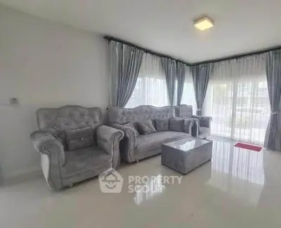 Spacious living room with elegant gray furniture and large windows for natural light.