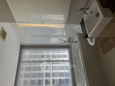 Modern bathroom with sleek fixtures and large window offering natural light.