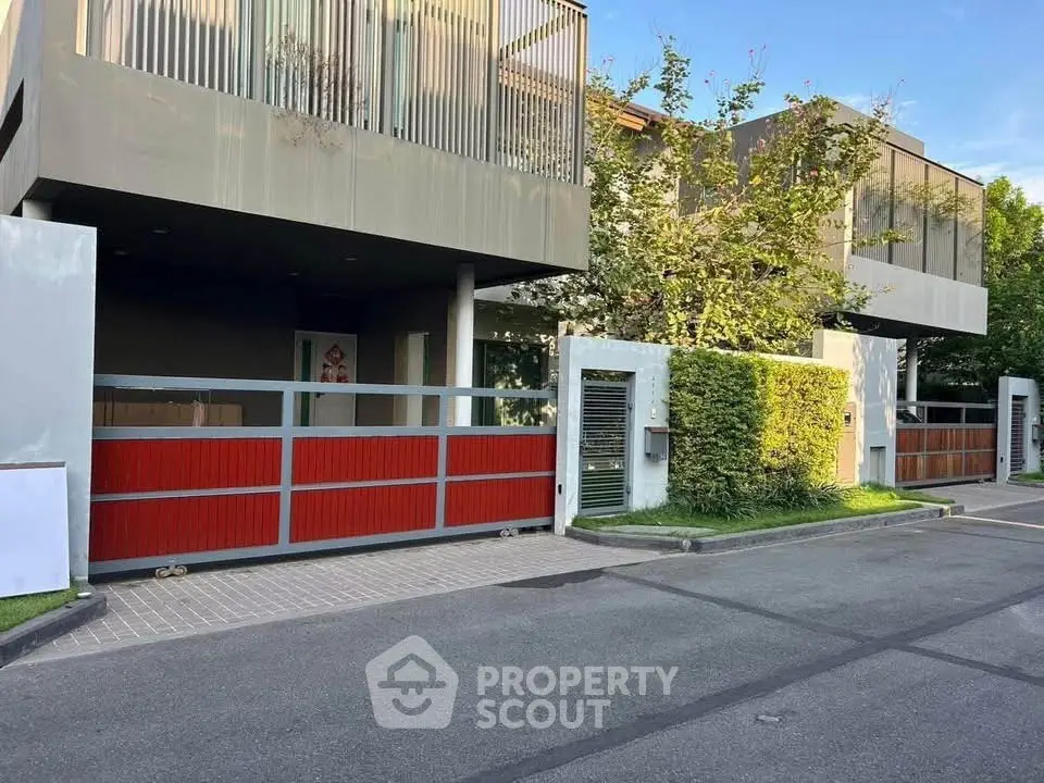 Modern residential building with sleek design and gated entrance in a serene neighborhood.