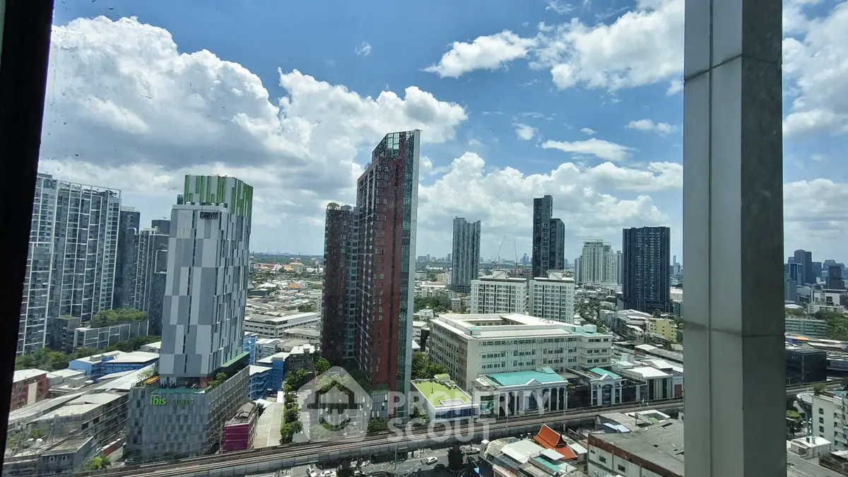 Stunning cityscape view from high-rise building with modern architecture and clear blue sky.