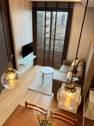 Stylish modern living room with cozy sofa, wooden flooring, and elegant lighting in a contemporary apartment.