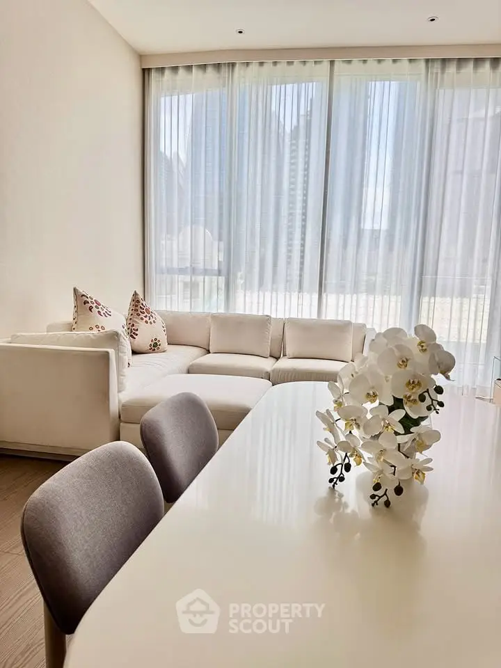 Elegant living room with modern decor and large windows offering a stunning city view.