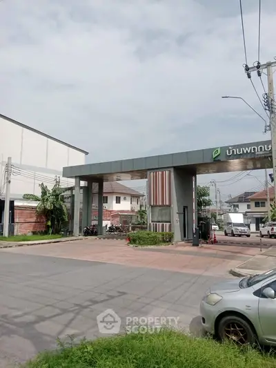 Modern residential entrance with sleek design and security gate in a suburban neighborhood.