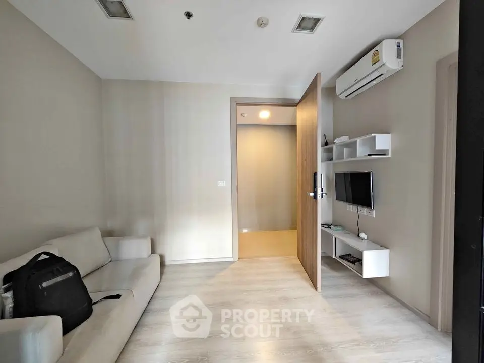 Modern living room with sleek design and wall-mounted TV in cozy apartment