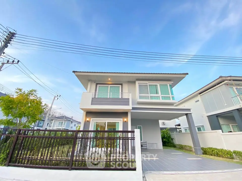 Modern two-story house with spacious balcony and front yard in a serene neighborhood.