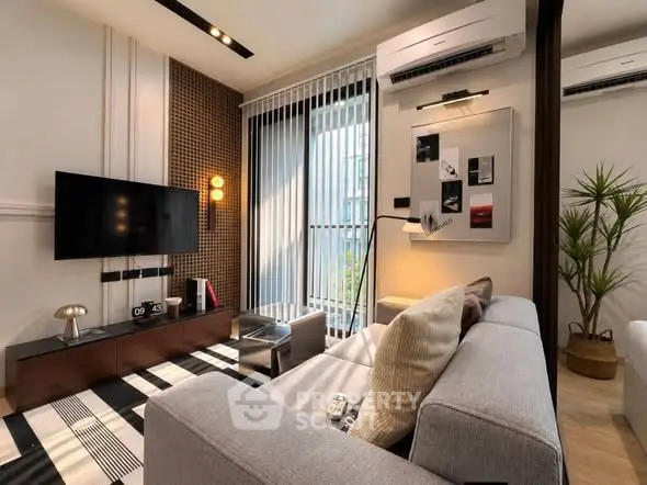 Modern living room with stylish decor, large window, and sleek furniture in a contemporary apartment.