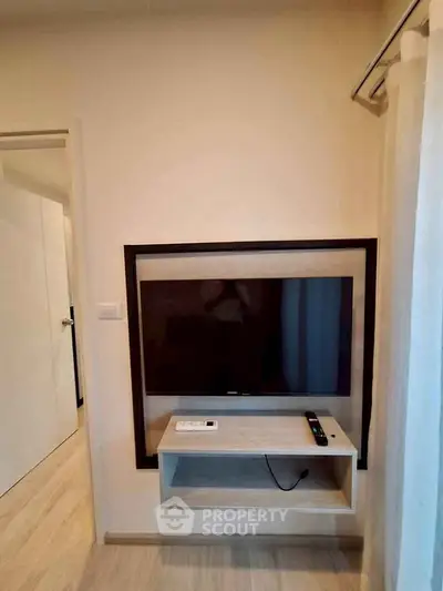 Modern living room with wall-mounted TV and sleek wooden flooring