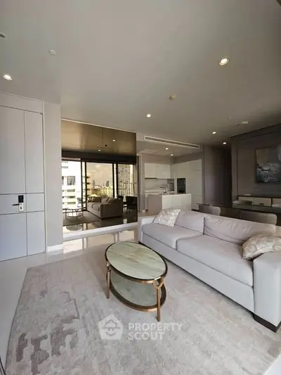 Spacious modern living room with open layout and city view, featuring elegant furniture and natural light.