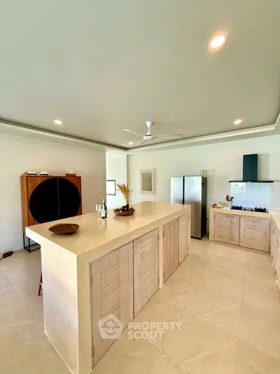 Spacious modern kitchen with island and sleek appliances in a bright, open layout.