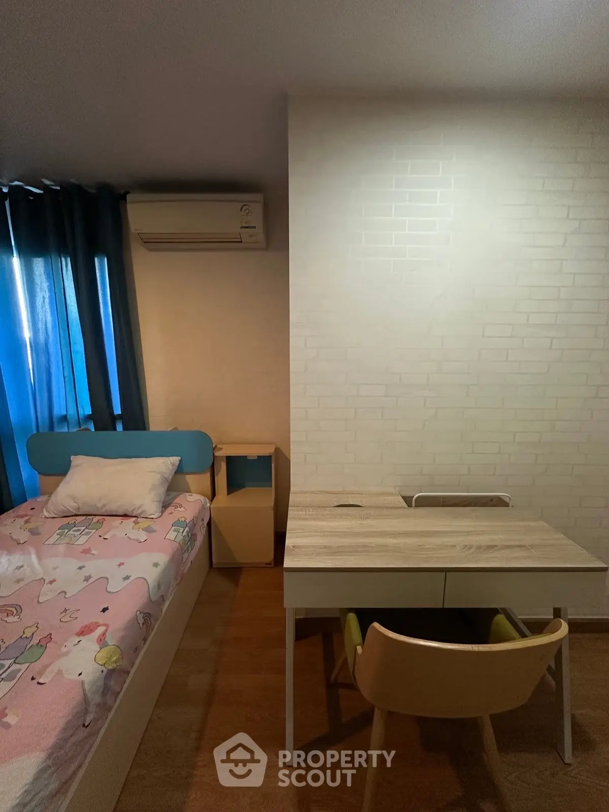 Cozy bedroom with study area, featuring a single bed and modern desk setup.