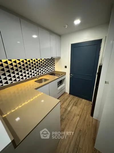 Modern kitchen with sleek cabinets and geometric backsplash design