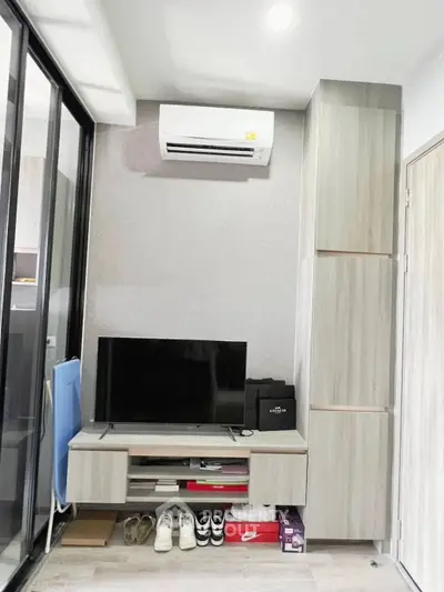 Modern living room with air conditioning and sleek TV setup in stylish apartment.