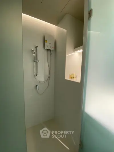 Modern minimalist bathroom with sleek shower design and built-in shelf