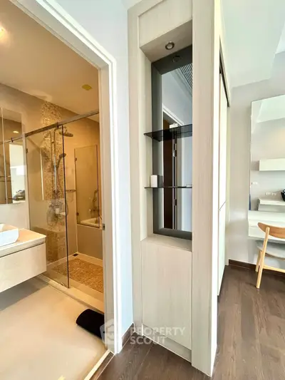 Modern bathroom with glass shower and stylish vanity in contemporary apartment.