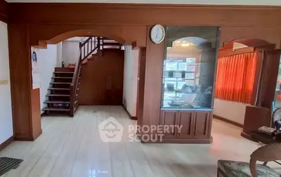 Spacious living area with wooden accents and staircase, ideal for family gatherings.