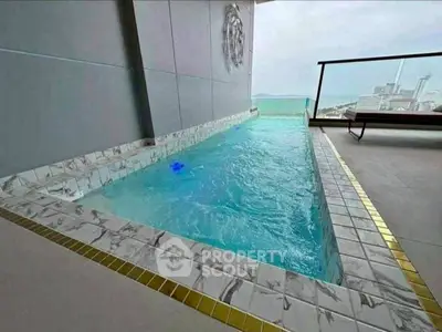 Luxurious rooftop pool with stunning city and ocean view, perfect for relaxation and entertainment.