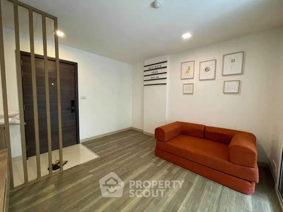 Modern living room with stylish orange sofa and wooden flooring, perfect for cozy urban living.