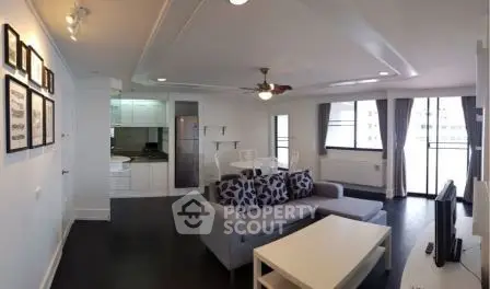 Spacious modern living room with open kitchen and large windows in a stylish apartment.