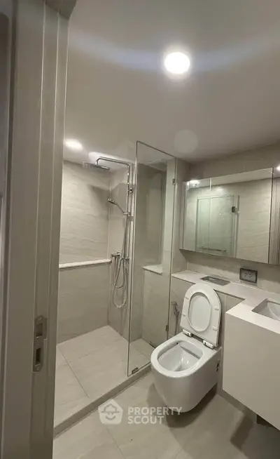 Modern bathroom with glass shower and sleek fixtures in a contemporary apartment.