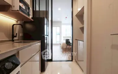 Modern apartment interior with sleek kitchen and view into cozy bedroom