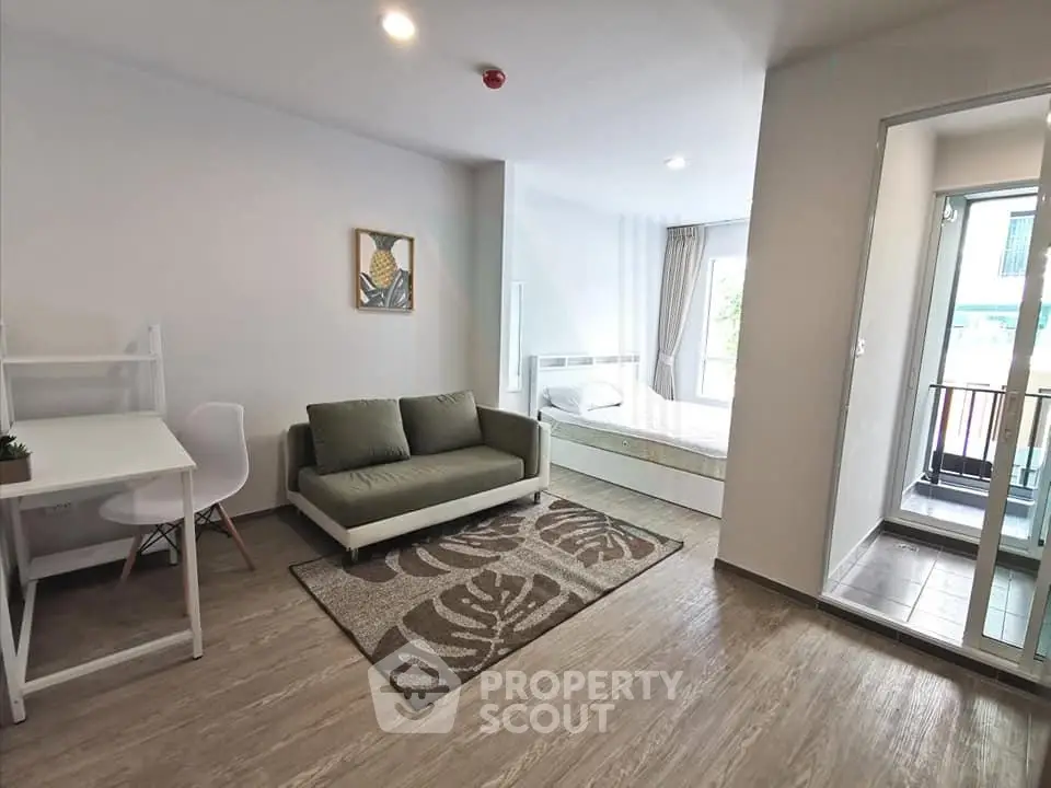 Modern studio apartment with stylish living area and cozy bedroom, featuring a balcony view.