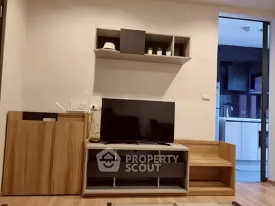 Modern living room with sleek TV stand and open kitchen view, perfect for contemporary urban living.