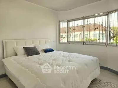 Bright bedroom with large windows and cozy bed in modern home