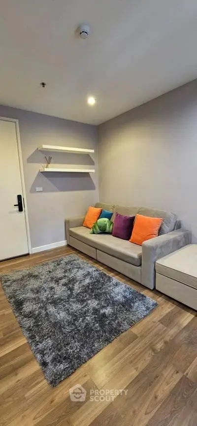 Cozy living room with modern decor and colorful cushions, perfect for relaxation.