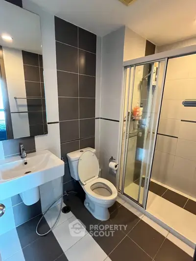 Modern bathroom with sleek design featuring a shower and contemporary fixtures.