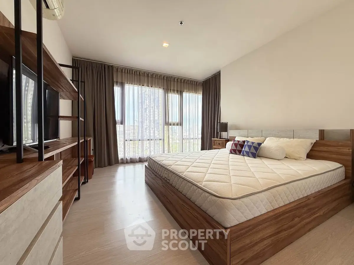 Spacious modern bedroom with large windows and stylish wooden furniture