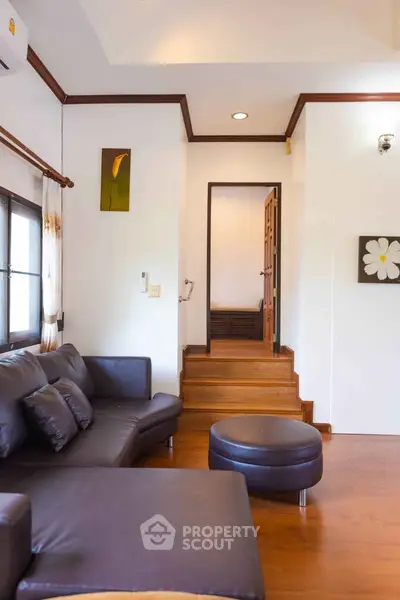 Cozy living room with leather sofa and wooden flooring in modern home