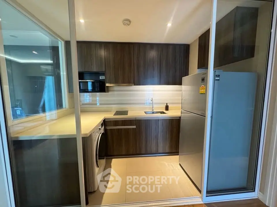 Modern kitchen with sleek cabinetry, built-in appliances, and ample counter space in a contemporary apartment.