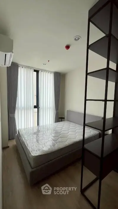 Modern bedroom with natural light and minimalist design in a stylish apartment.