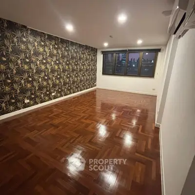 Spacious living room with elegant parquet flooring and city view.
