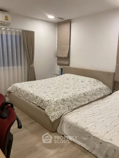 Cozy bedroom with double beds and modern decor, perfect for restful nights.