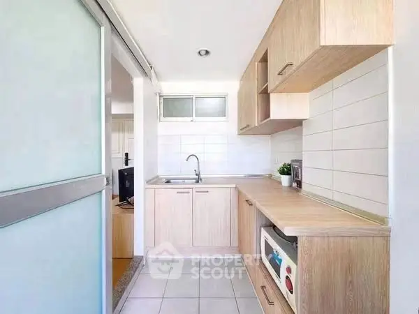 Modern kitchen with sleek wooden cabinetry and built-in appliances.