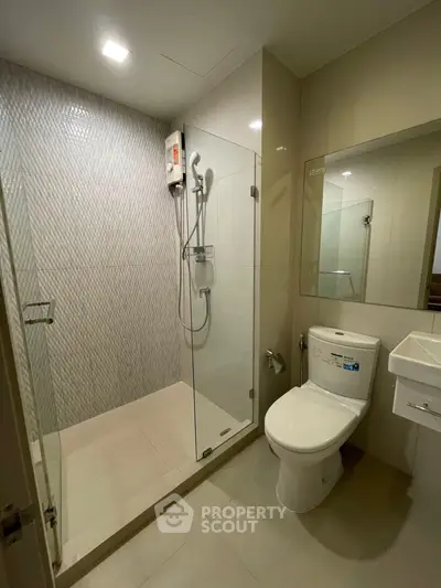 Modern bathroom with glass shower and sleek fixtures in a contemporary home.
