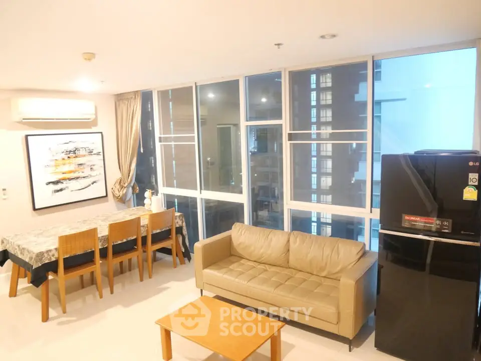 Modern living room with dining area and large windows in a stylish apartment.