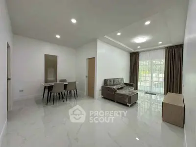 Spacious modern living room with sleek furniture and dining area, perfect for family gatherings.