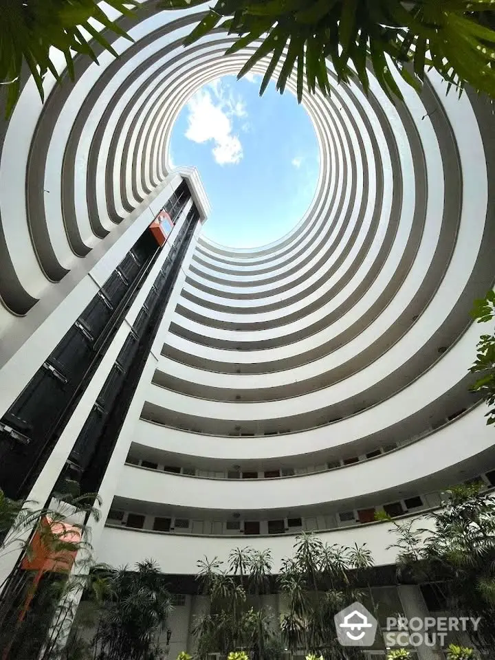 Stunning architectural view of a modern circular building with open sky above.