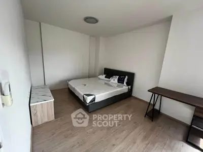 Spacious minimalist bedroom with modern furnishings and wooden flooring