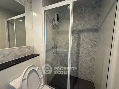 Modern bathroom with glass shower enclosure and sleek tile design