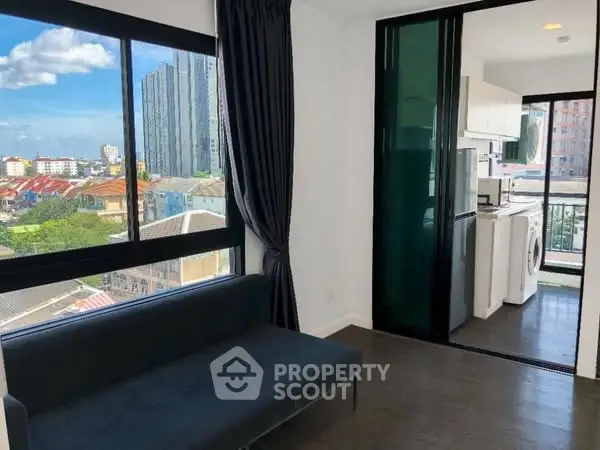 Modern apartment with city view and sleek kitchen featuring washing machine.
