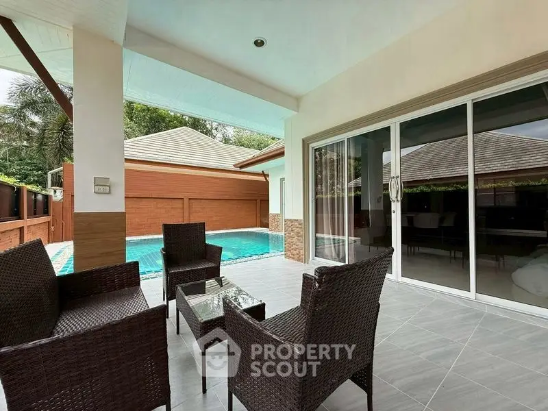 Charming patio with pool view in modern villa, perfect for relaxation and entertaining.