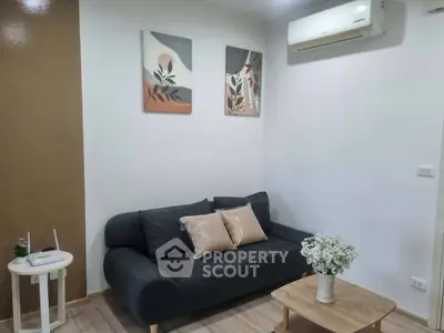 Cozy living room with modern decor and air conditioning, perfect for relaxation.