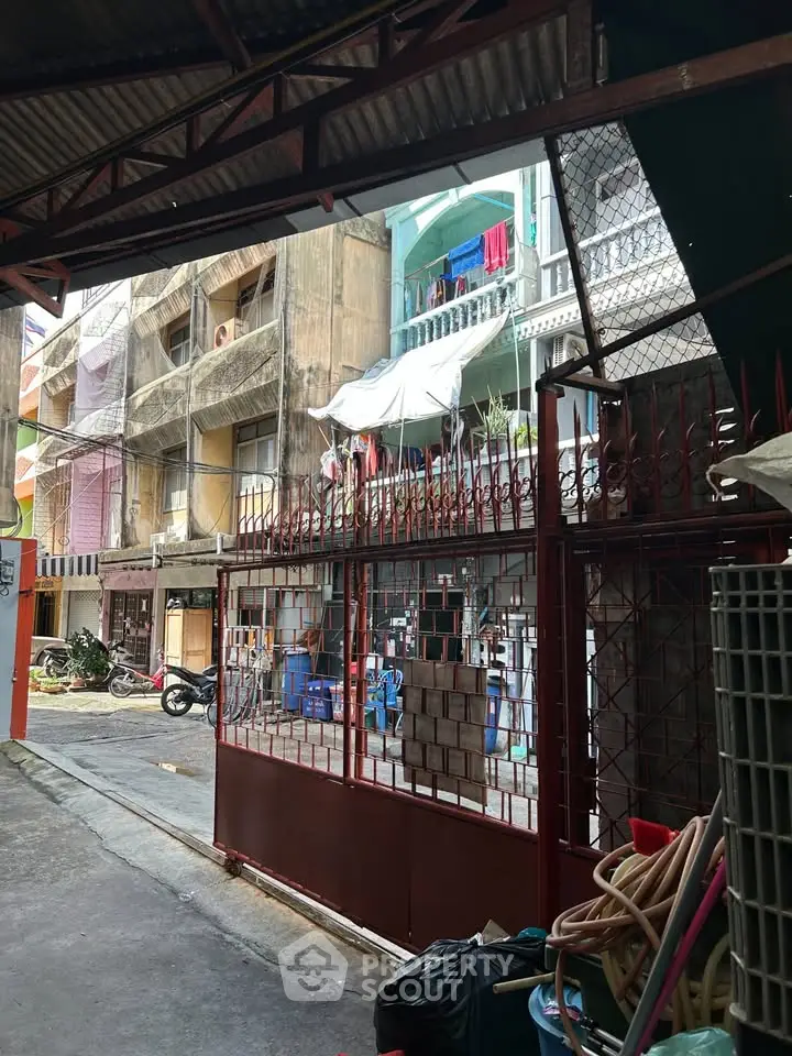 Urban residential building exterior with gated entrance and street view.
