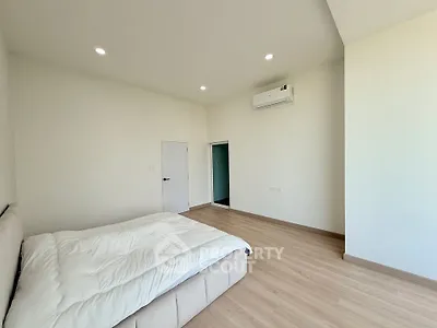 Spacious minimalist bedroom with modern air conditioning and cozy bed in a bright apartment.