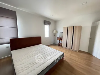 Spacious bedroom with wooden flooring and modern furniture