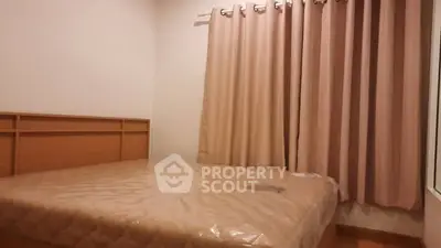 Cozy bedroom with neutral tones and large window curtains